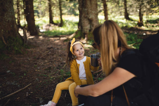 istock Lovely daughter drinking tea with mother in a forest 1043734950