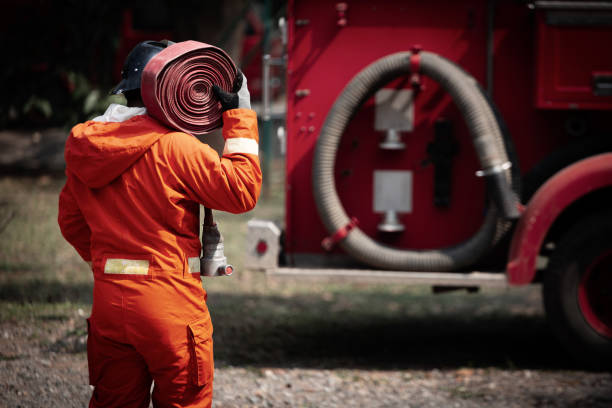 istock Firefighters training, Team practice to fighting with fire in emergency situation. A fireman carry a water hose run through flame 1043738476