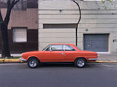 Orange vintage car parked in the street