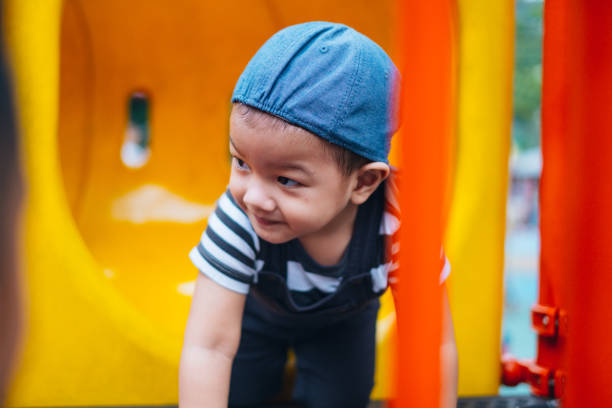 istock Young Malaysian Toddler Playing at Public Playground 1043746372