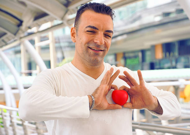 istock Handsome man show his emotion by raise heart up on his hands 1043748048