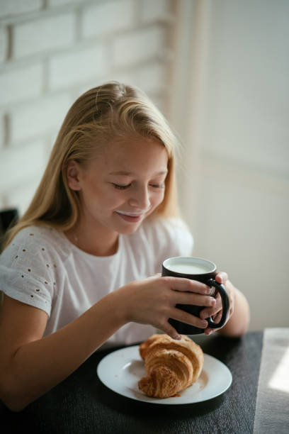 istock Beautiful young girl having breakfast 1043748936