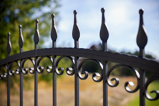 Brown iron gate across Alberta prairie land. Crops in background.Clear blue sky . No people.