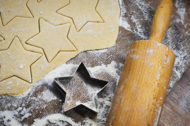 istock Christmas baking. Making gingerbread biscuits. Cookie dough, cookie cutters and rolling pin on kitchen counter. Top view. 1043757346