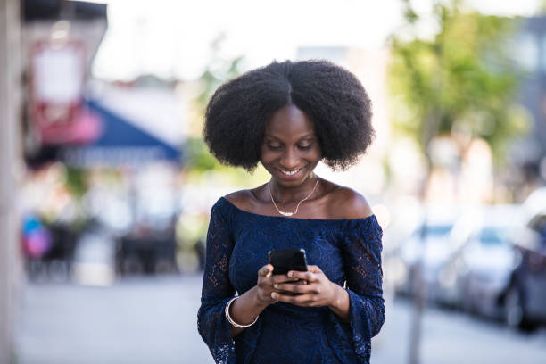 istock Smiling African Immigrant Woman Texting On Smartphone 1043760406