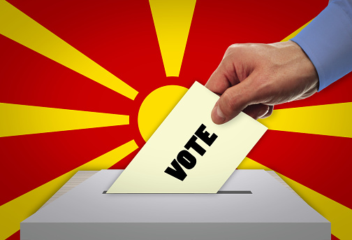 Man voting on elections in MACEDONIA front of flag