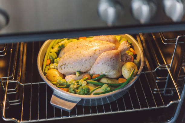 istock Cook putting raw chicken to the oven 1043761078