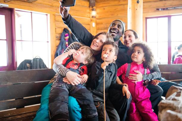 multi-ethnic family in a ski cottage, apres-ski break - apres ski winter friendship ski imagens e fotografias de stock