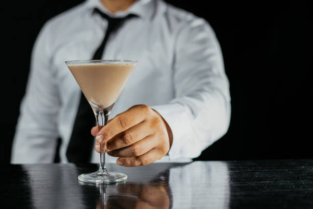 istock Bartender serving cocktail in martini glass 1043778714
