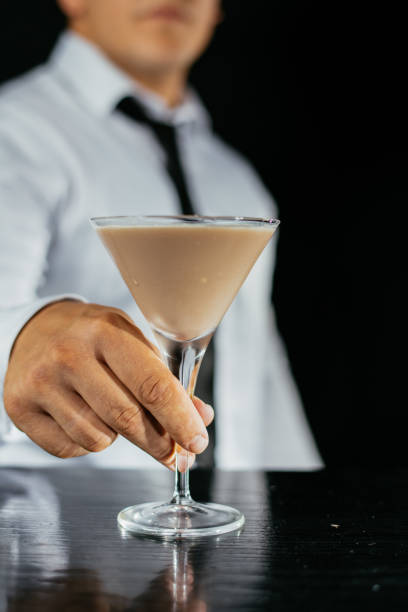 istock Bartender serving cocktail in martini glass 1043778822
