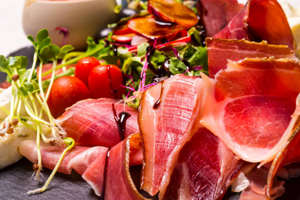 istock Prosciutto, cheese and lettuce on a stone plate 1043778888