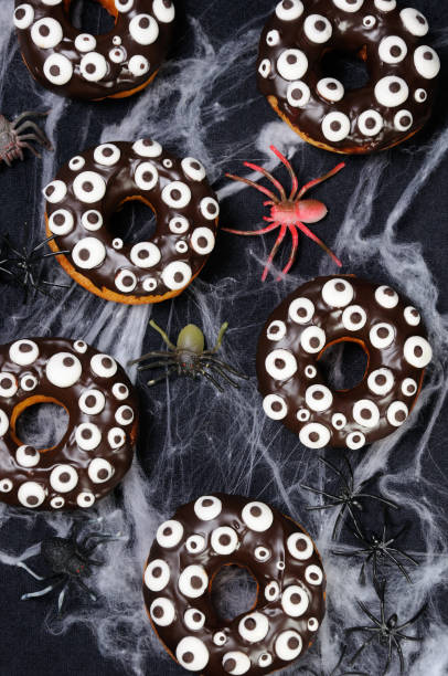 istock Donuts with chocolate icing decorated googly eyes monster on Halloween 1043801480