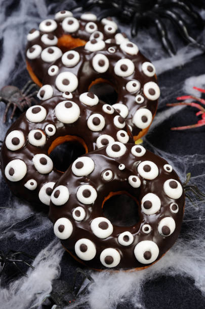 istock Donuts with chocolate icing decorated googly eyes monster on Halloween 1043801486