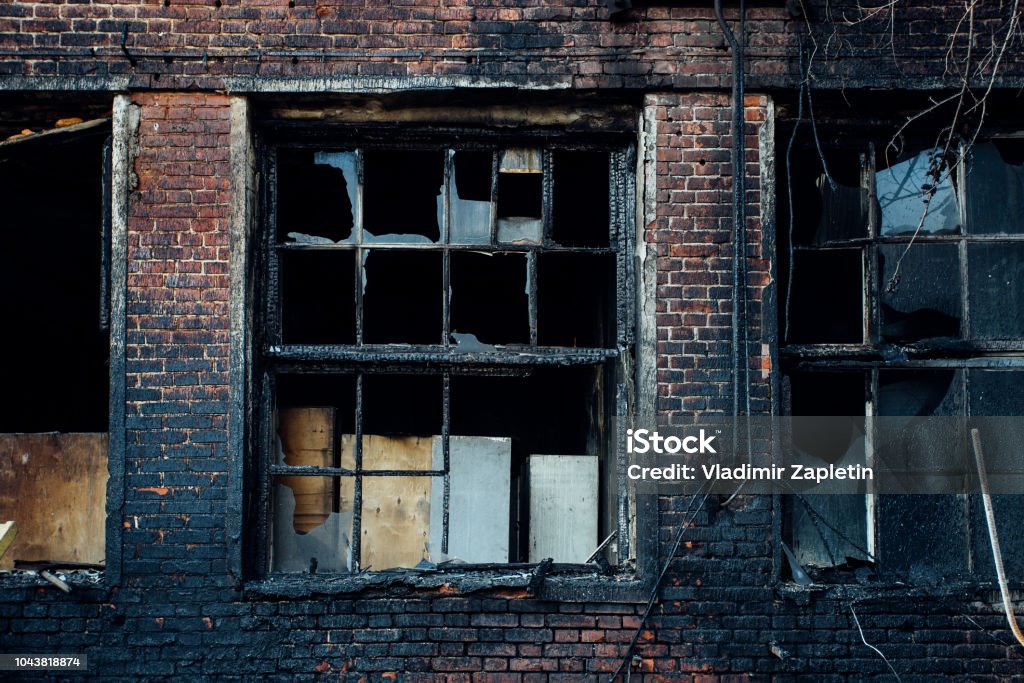 Trasigt fönster av bränd röd tegelbyggnad - Royaltyfri Bränd Bildbanksbilder