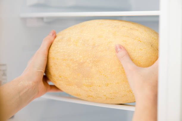 istock Female hands take melon from fridge close up 1043833578