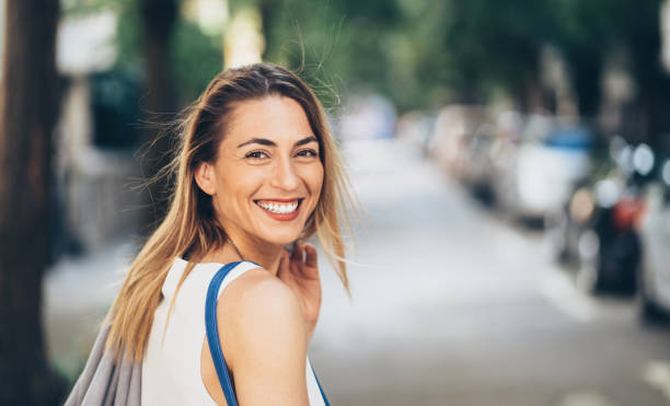 Beautiful woman looking back over her shoulder Beautiful woman looking back over her shoulder on the street turning back stock pictures, royalty-free photos & images