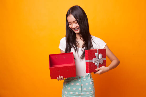 istock Young Asian woman open a golden gift box. 1043837870