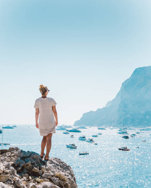 カプリ島を見渡す女性。 - beautiful pink blue lifestyles ストックフォトと画像