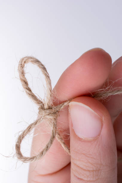 istock Thread knot in hand on a light color background 1043849130