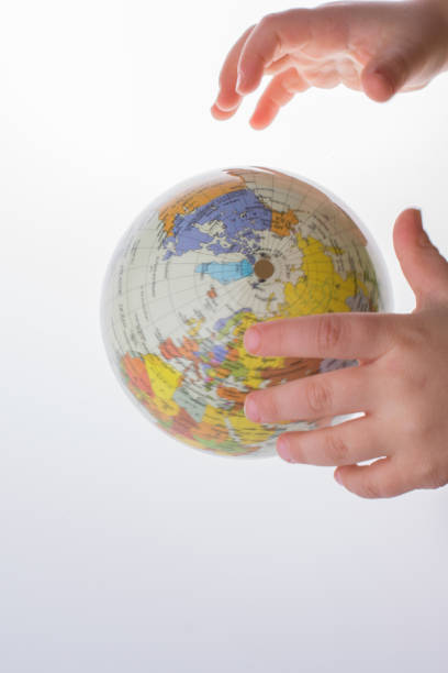 istock Child holding a globe in his hand 1043849178