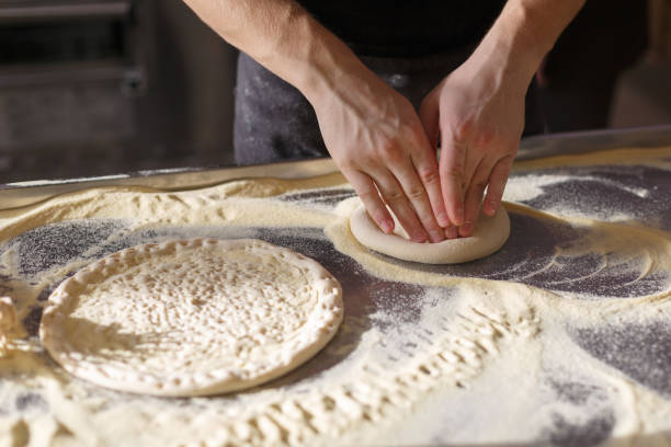 istock Baker makes a second base of pizza in the kitchen in a restaurant 1043868556