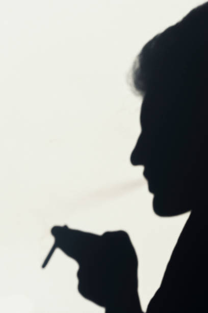 istock shadow of smoking man, young man smoking a cigarette, concept abstract background 1043878466