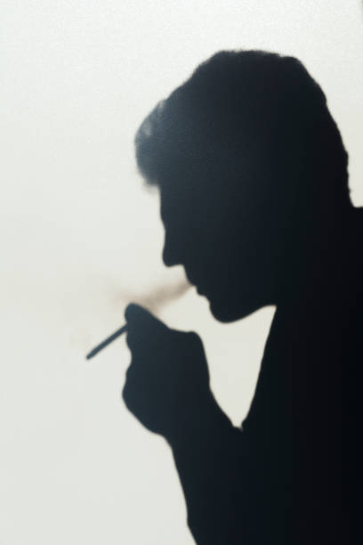 istock shadow of smoking man, young man smoking a cigarette, concept abstract background 1043878498