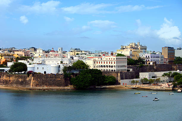 Travel image of old San Juan with city and historic walls along the waterfront , close at the port of San Juan, Puerto Rico.
