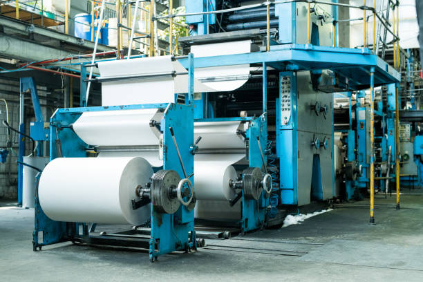 Large printing press with paper roll printing newspaper on production line of industrial printing machine stock photo