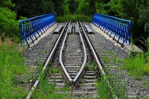 Lagow, Poland, June 2018. The length of the old abandoned railway track. Railroad, Train railroad tracks on the bridge with blue handrails.