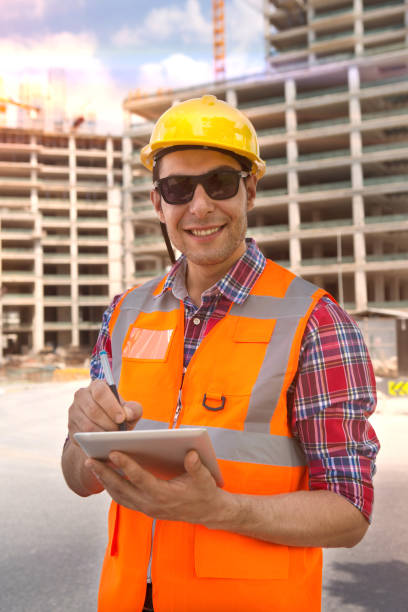 istock Young Engineer portrait with construction site and crane background. 1043921234