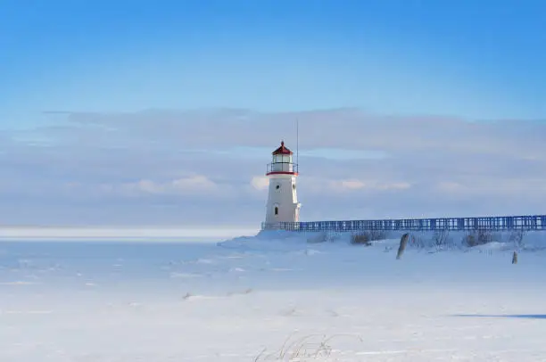 Photo of Lighthouse in a calm and desolate winter landscape.