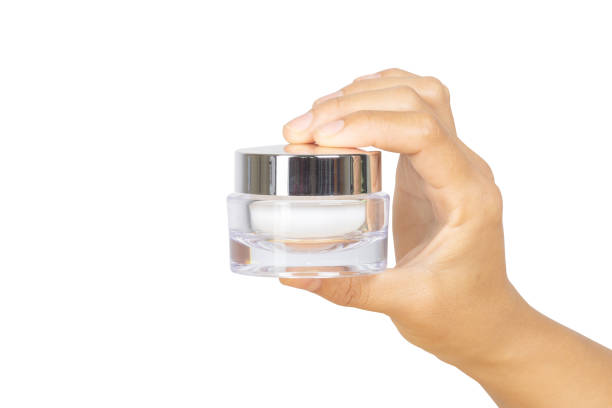 istock Hand holding cream bottle isolated on white background with clipping path. 1043930272