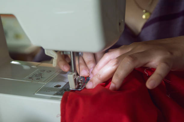 istock Woman seamstress working making clothes on a sewing machine. 1043934090
