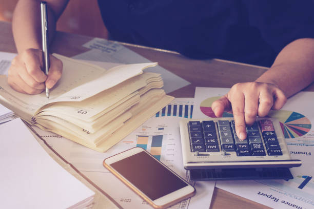 istock Business concept : close up woman hand using calculator and writing make note with calculate at office desk. 1043937318