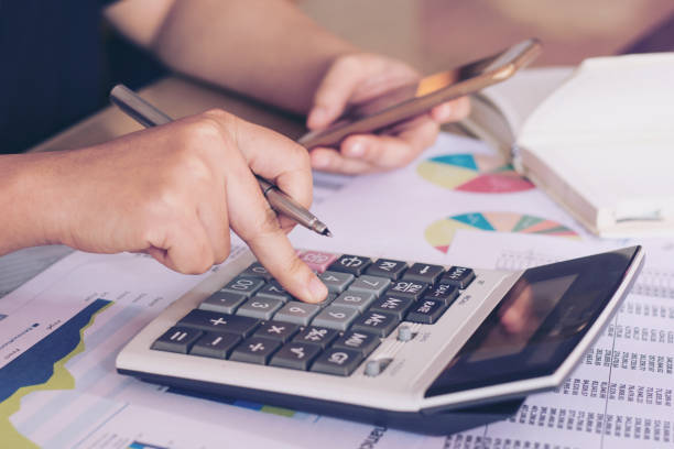 istock Business concept : close up woman hand using calculator and using smartphone on office desk. 1043939492
