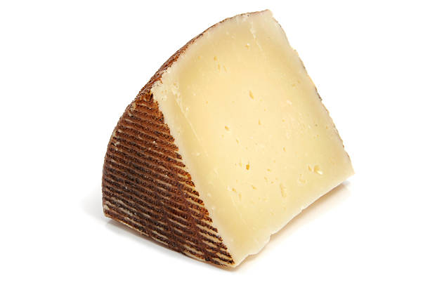 A slice of Manchego cheese with the rind on stock photo