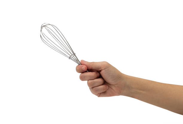 istock Female hand with a kitchen whisk isolated on white background 1043954104