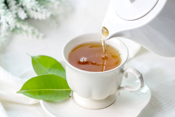 화이트 티 컵, 다도 시간 개념에에서 쏟아지는 뜨거운 홍차를 닫습니다 - jasmine tea jasmine tea green 뉴스 사진 이미지