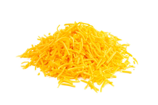 A Pile of Grated Cheddar Cheese on a White Background stock photo