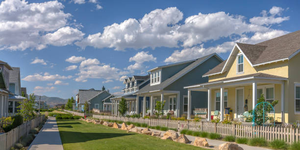 istock Row of houses under blue sky and puffy clouds 1043997896