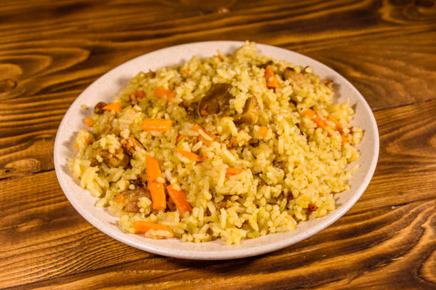 istock Ceramic plate with pilaf on wooden table 1044006164