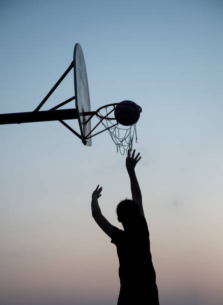 istock Silhouette basketball player shooting at a hoop 1044019794