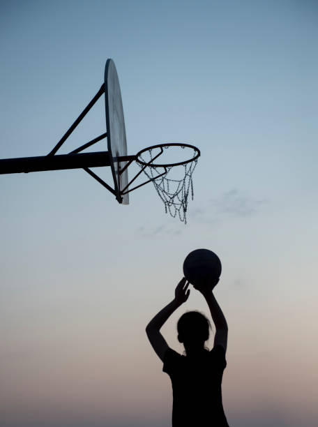 istock Silhouette basketball player shooting at a hoop 1044019836