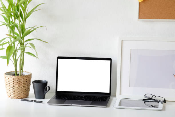 istock Workspace laptop computer and coffee cup, tablet and glasses on office desk with mockup laptop. 1044026038