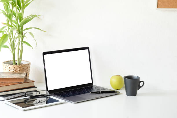 istock Workspace laptop computer and coffee cup, tablet and glasses on office desk with mockup laptop. 1044026230