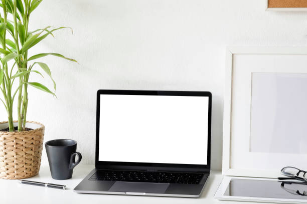 istock Workspace laptop computer and coffee cup, tablet and glasses on office desk with mockup laptop. 1044028732