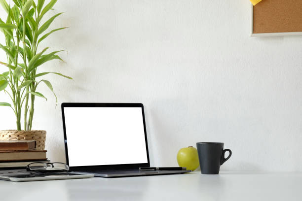 istock Workspace laptop computer and coffee cup, tablet and glasses on office desk with mockup laptop. 1044028808