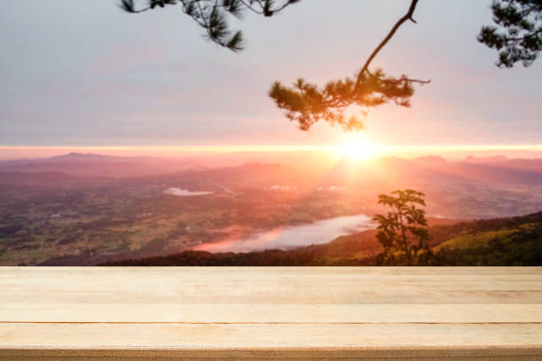 istock Wooden desk table with mountain in forest sun light morning time table is empty. 1044032214