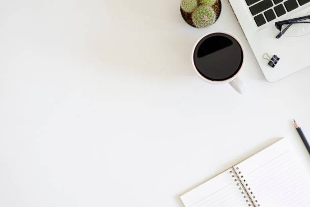 istock Top view office table with laptop computer, cup of coffee, cactus, glasses, notepad paper and pencil with copy space on work space. 1044032616